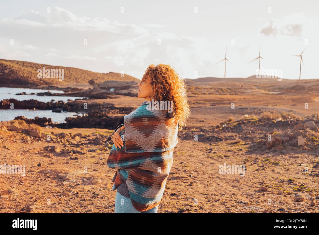 One woman standing and hugging herself enjoying a beautiful landscape ...