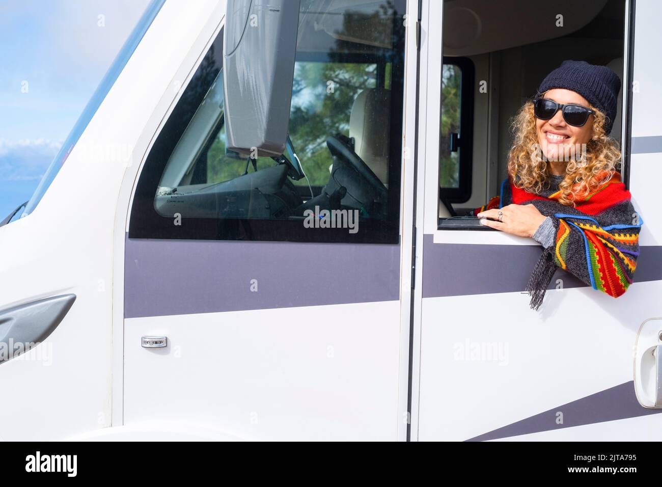 Happy woman drive big camper van motor home and smile outside the window. Concept of transport caravan summer holiday vacation people. Portrait of dri Stock Photo