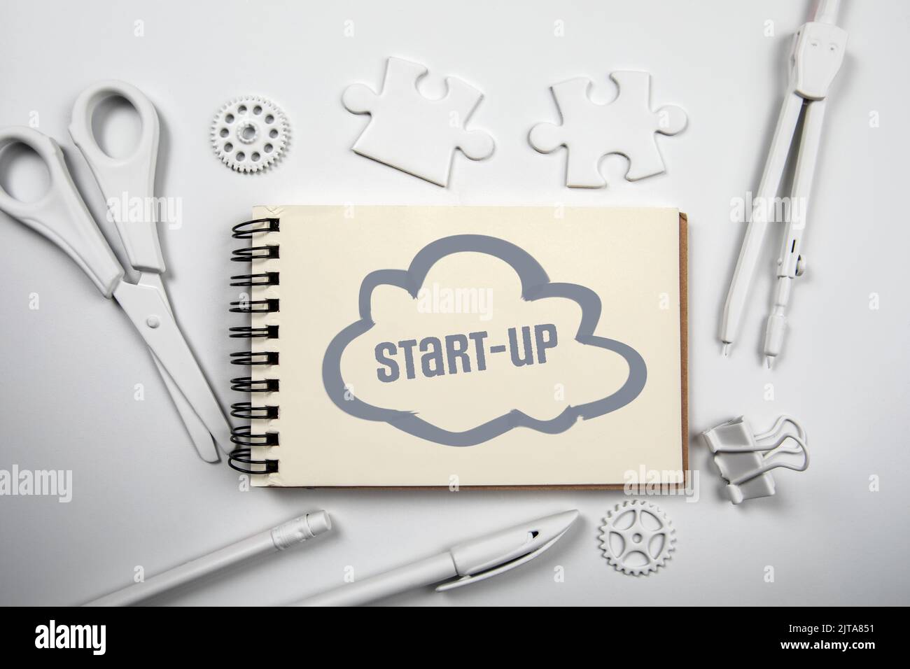 Start-Up. Text and cloud on notepad. White office desk. Stock Photo