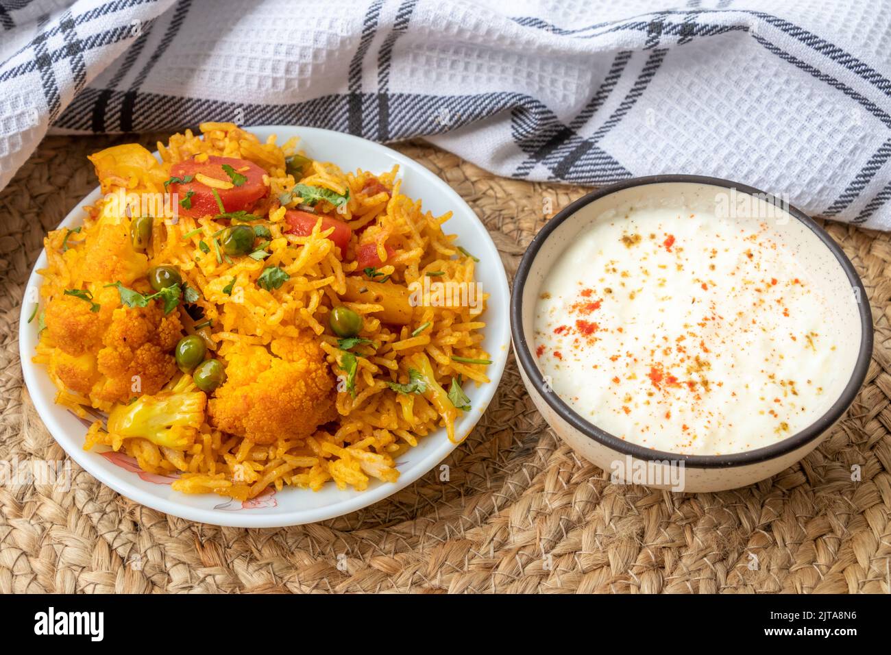 Vegetable pulao recipe with curd made with basmati rice and mix vegetables served in a round plate Stock Photo