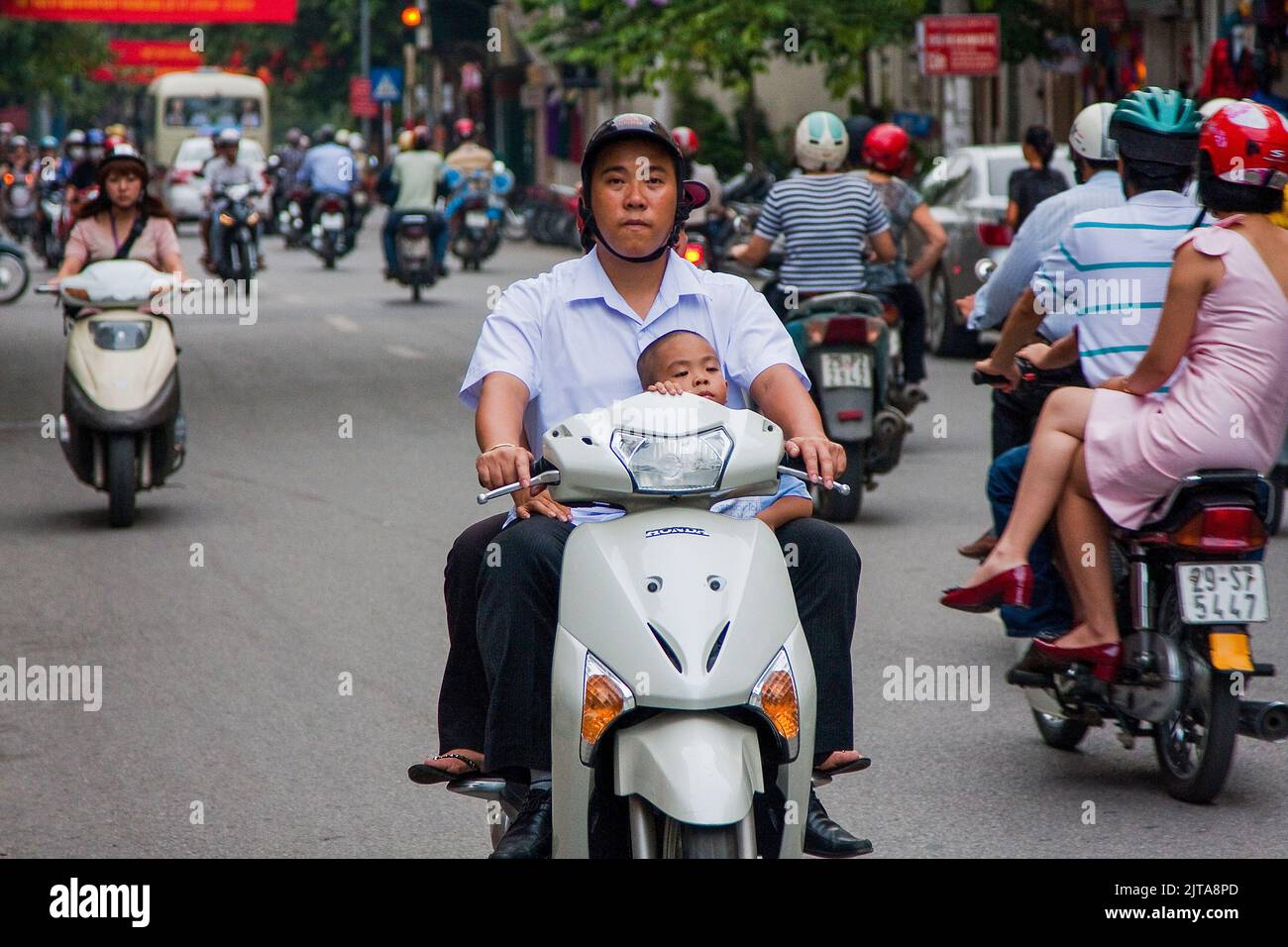 Vietnam, Hanoi Scooters and small moterbikes are the most popular ways of transport. Bus and bicycle come next. A car is only for few people possible. Stock Photo