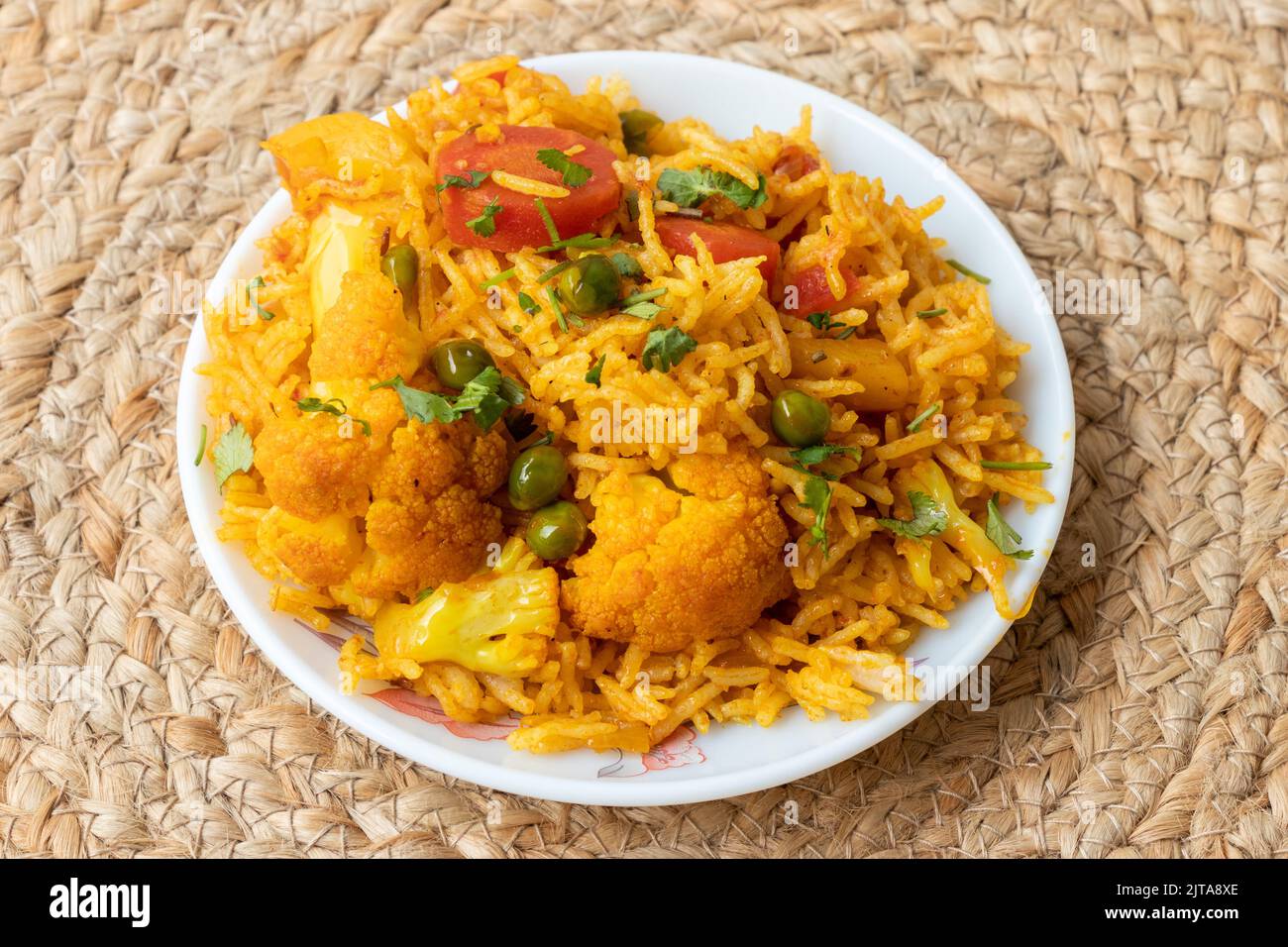 Indian vegetarian fried rice in the plate with carrot, spring onion, green peas, colliflower Stock Photo