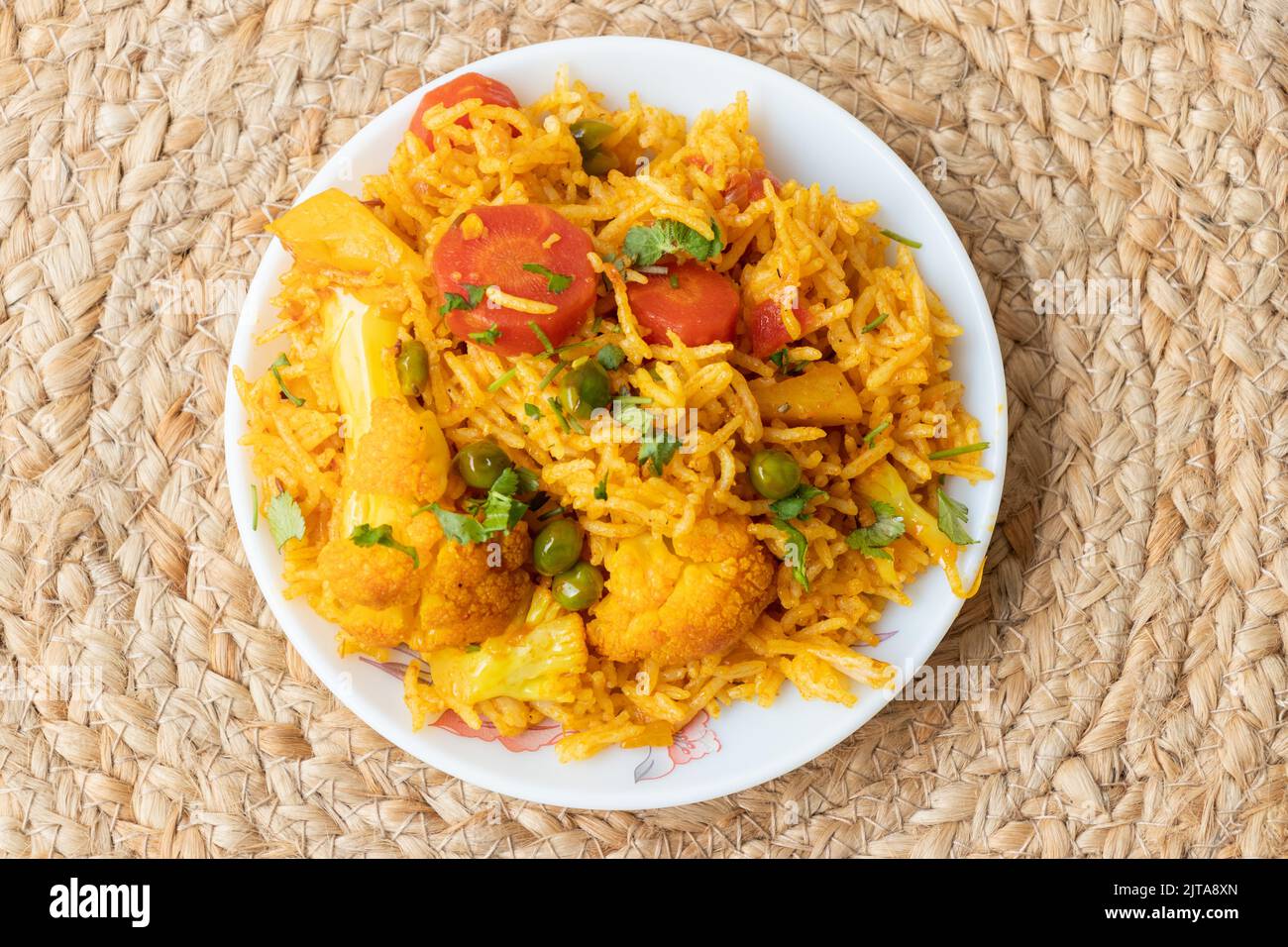 Indian vegetarian fried rice in the plate with carrot, spring onion, green peas, colliflower Stock Photo