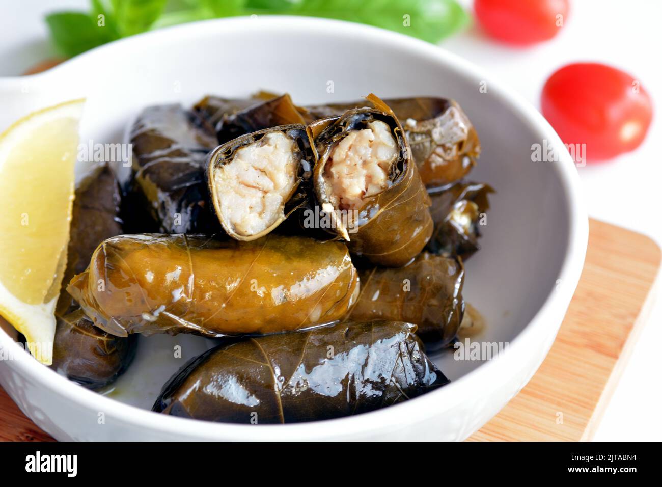 Grape leaf filled with rice served with lemon. Traditional Greek food Stock Photo