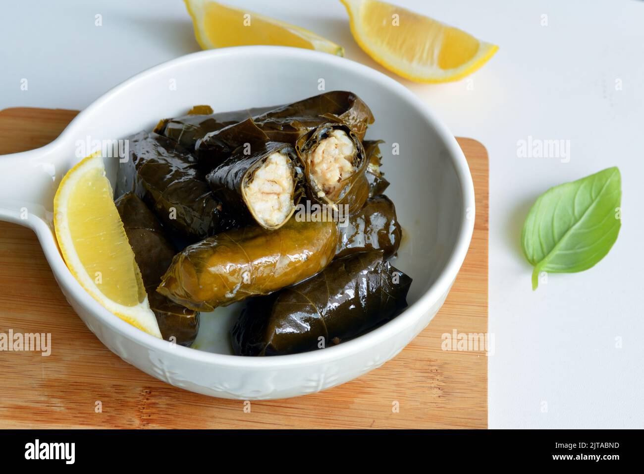 Grape leaf filled with rice served with lemon. Traditional Greek food Stock Photo