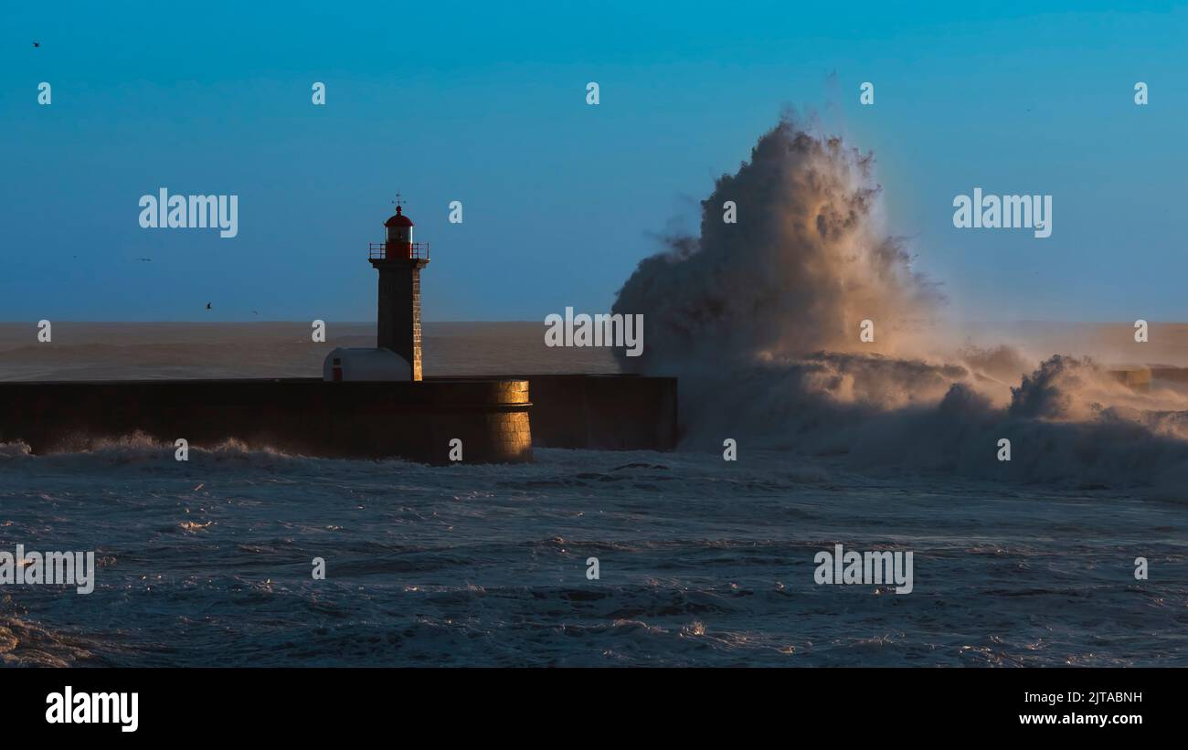 Lighthouse with huge wave at Atlantic ocean in Porto, Portugal. Stock Photo