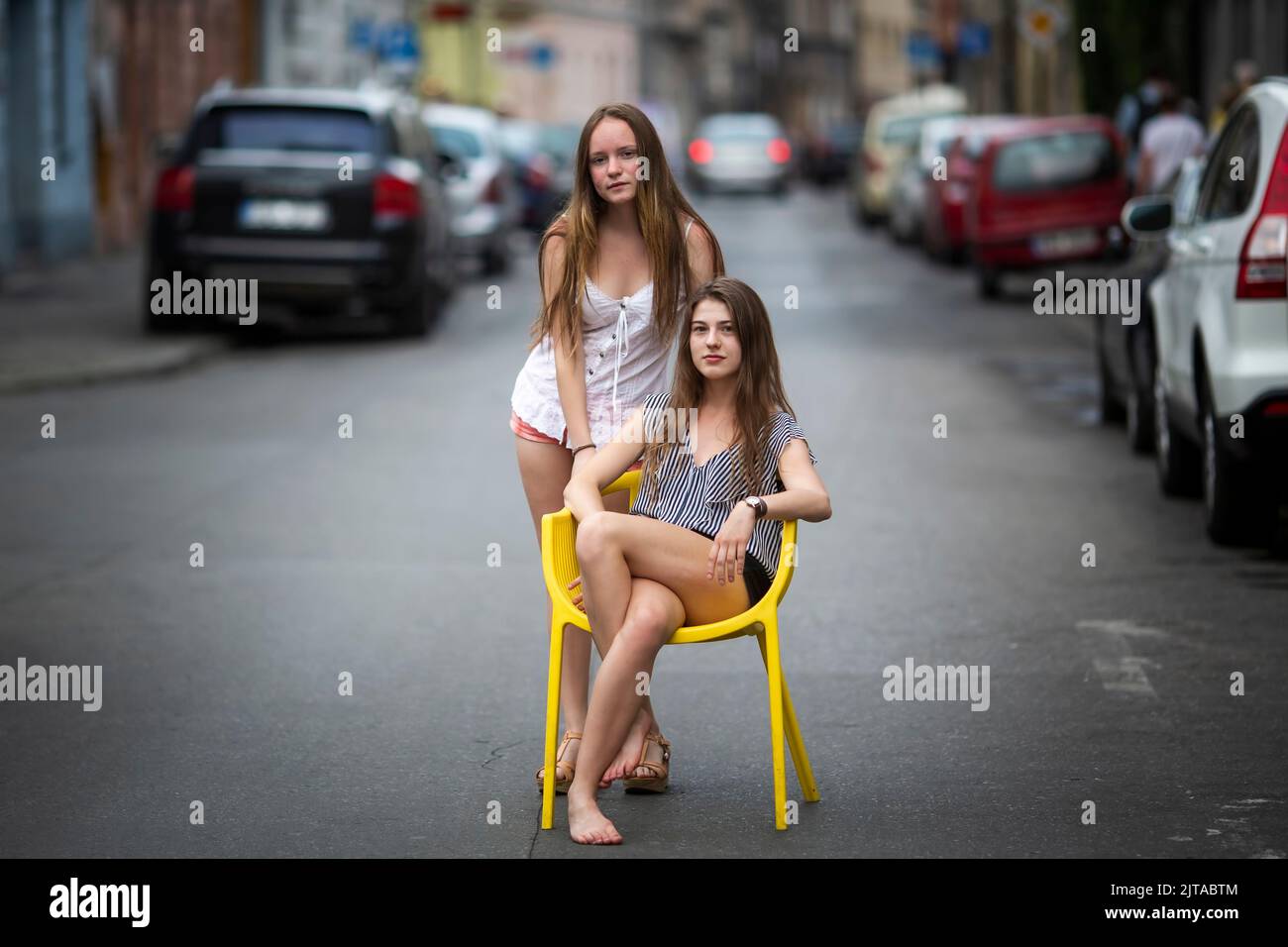 Two pretty girls girlfriends pose in the middle of the street. Stock Photo