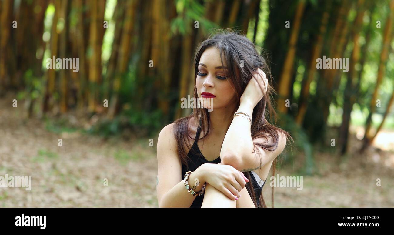 Contemplative young millennial sitted outside in nature thinking Stock ...