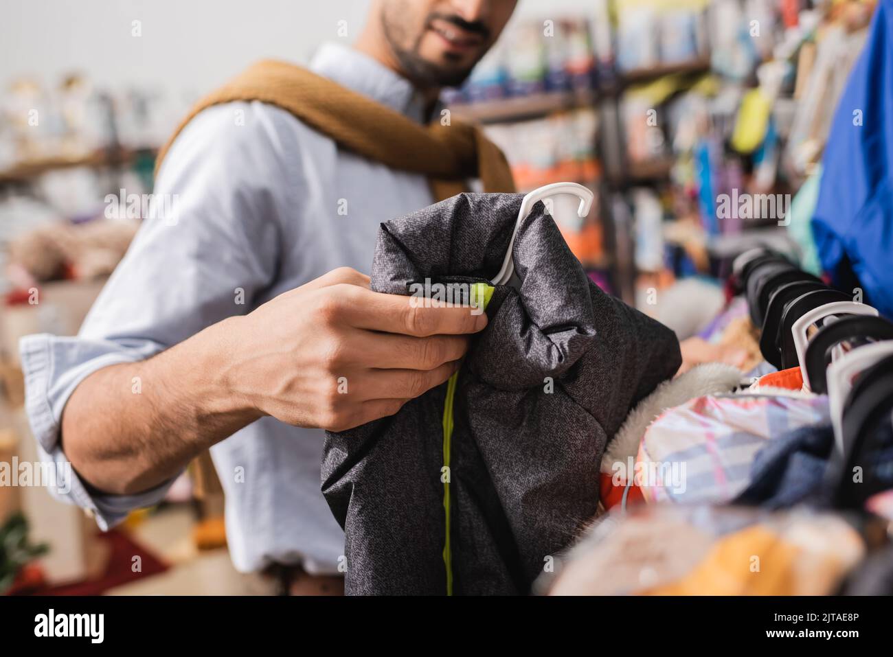 Cropped view of man holding animal jacket in pet shop Stock Photo