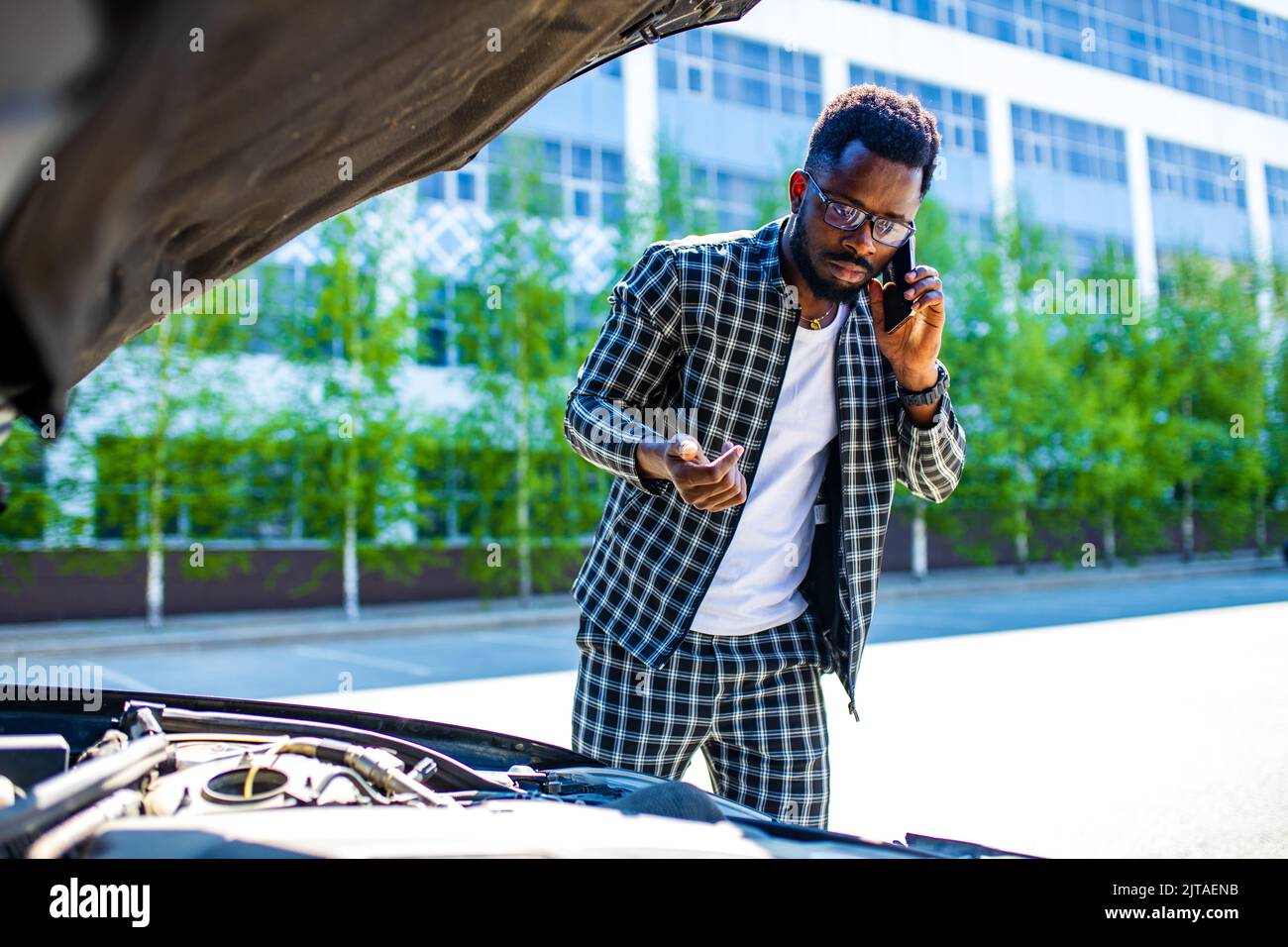 latin hispanic stressed man having trouble with his broken car outdoors Stock Photo