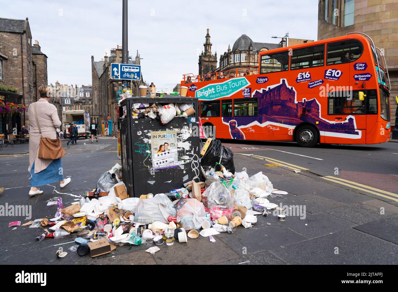 Edinburgh, Scotland, UK. 29th August 2022. Edinburgh bin men strike in second week and the city’s streets are covered in litter from overflowing rubbish bins. Pic; Tourist tour bus passes overflowing bin.  Iain Masterton/Alamy Live News Stock Photo