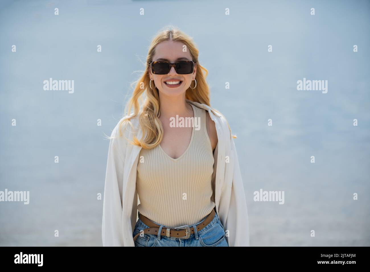 blonde and happy woman smiling at camera outdoors Stock Photo
