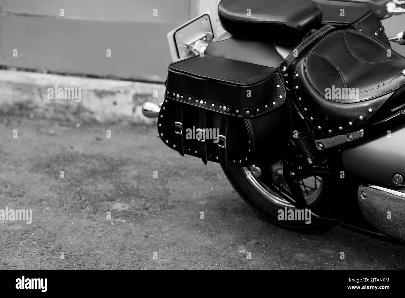 Vintage studded leather bag on a motorcycle. black and white image