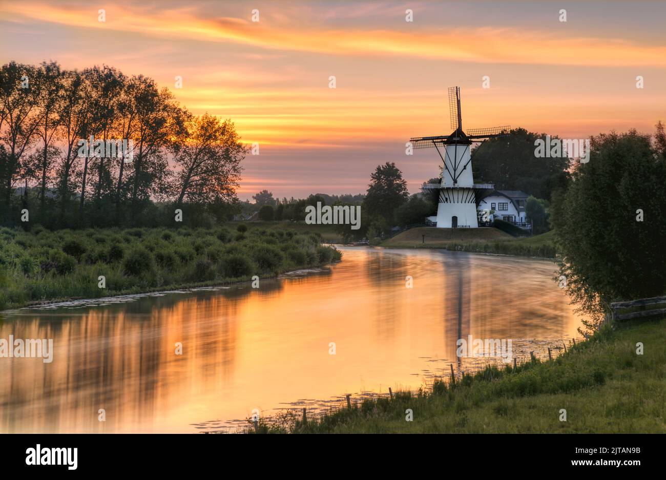 'De Vlinder' is a typical and picturesque Dutch windmill located in the central part of the Netherlands on the shores of the Linge River. Stock Photo