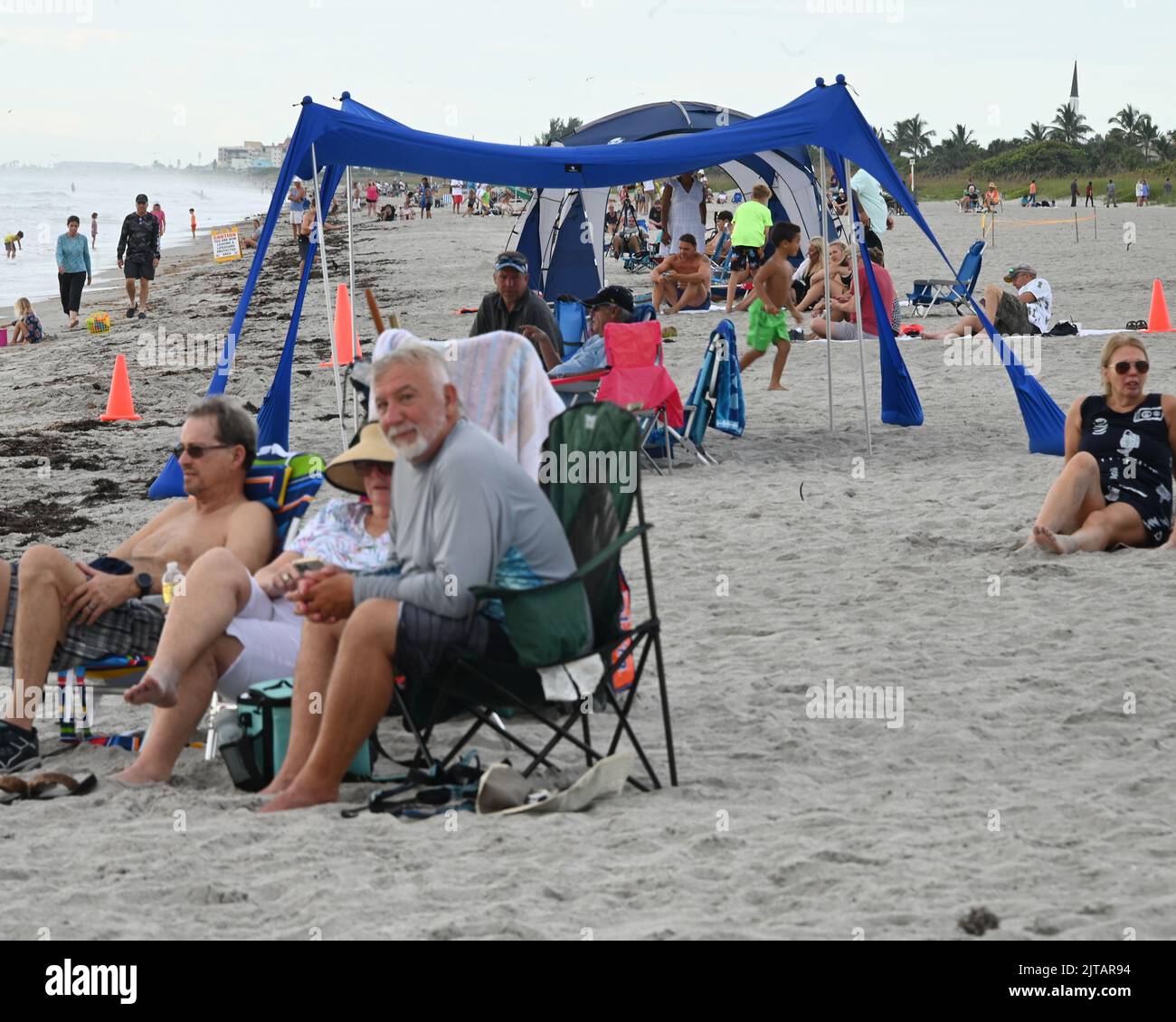 Cocoa Beach, United States. 29th Aug, 2022. People wait on the beach to