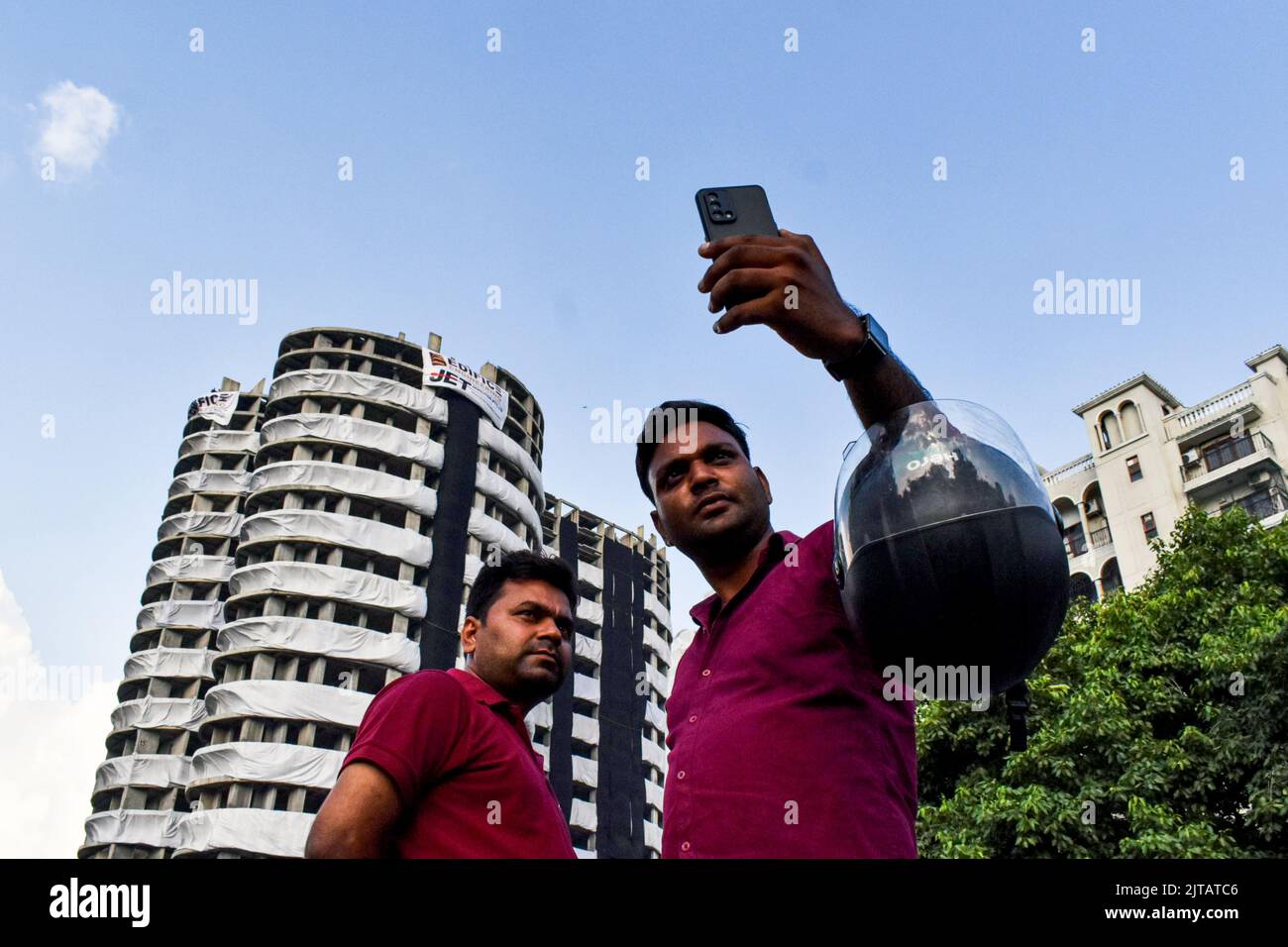 Noida, India. 27th Aug, 2022. People taking selfies with the Supertech twin towers ahead of their demolition with explosives in compliance with a Supreme Court order, in Noida, Saturday, Aug. 27, 2022.Over 3,700 kg explosives will be used to raze down the nearly 100-metre-tall structures on 28 August 2022. (Photo by Mohsin Javed/Pacific Press) Credit: Pacific Press Media Production Corp./Alamy Live News Stock Photo