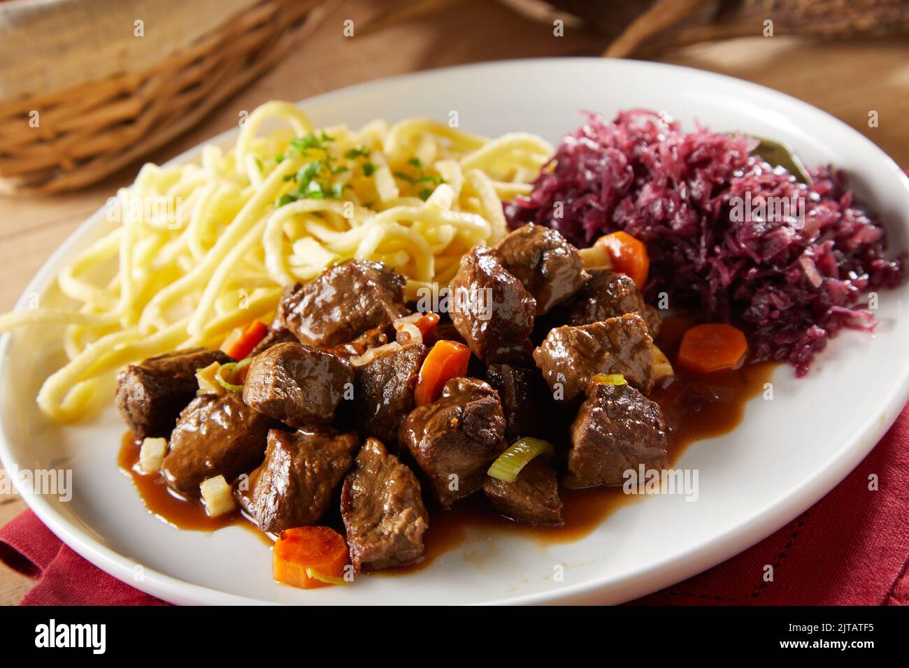 From above delectable beef and vegetables goulash with spatzle pasta and sauerkraut served for dinner on plate Stock Photo