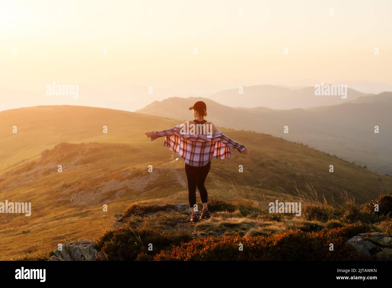 Alone girl on the mountain edge against the backdrop of an incredible autumn mountains landscape Stock Photo