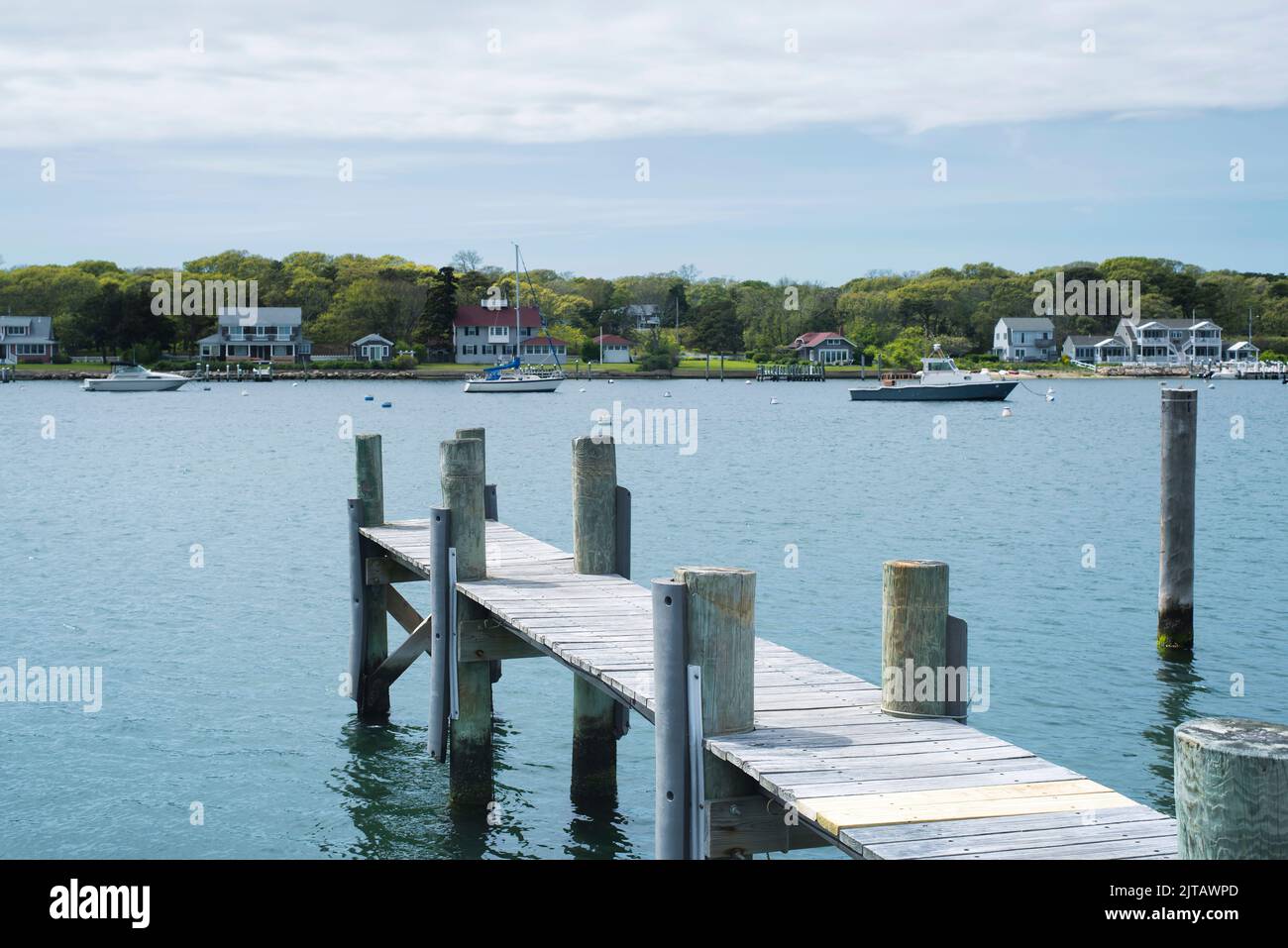 a wooden dock with the small town of oak bluffs massachusetts on martha's vineyard on an overcast day. Stock Photo