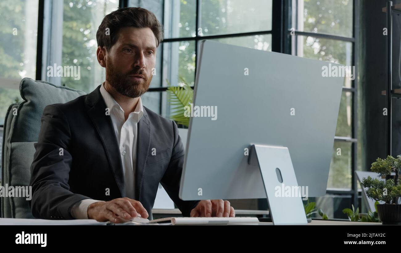 Caucasian busy serious bearded middle-aged 40s man worker in office working online commerce service trade in internet. Adult manager company CEO Stock Photo