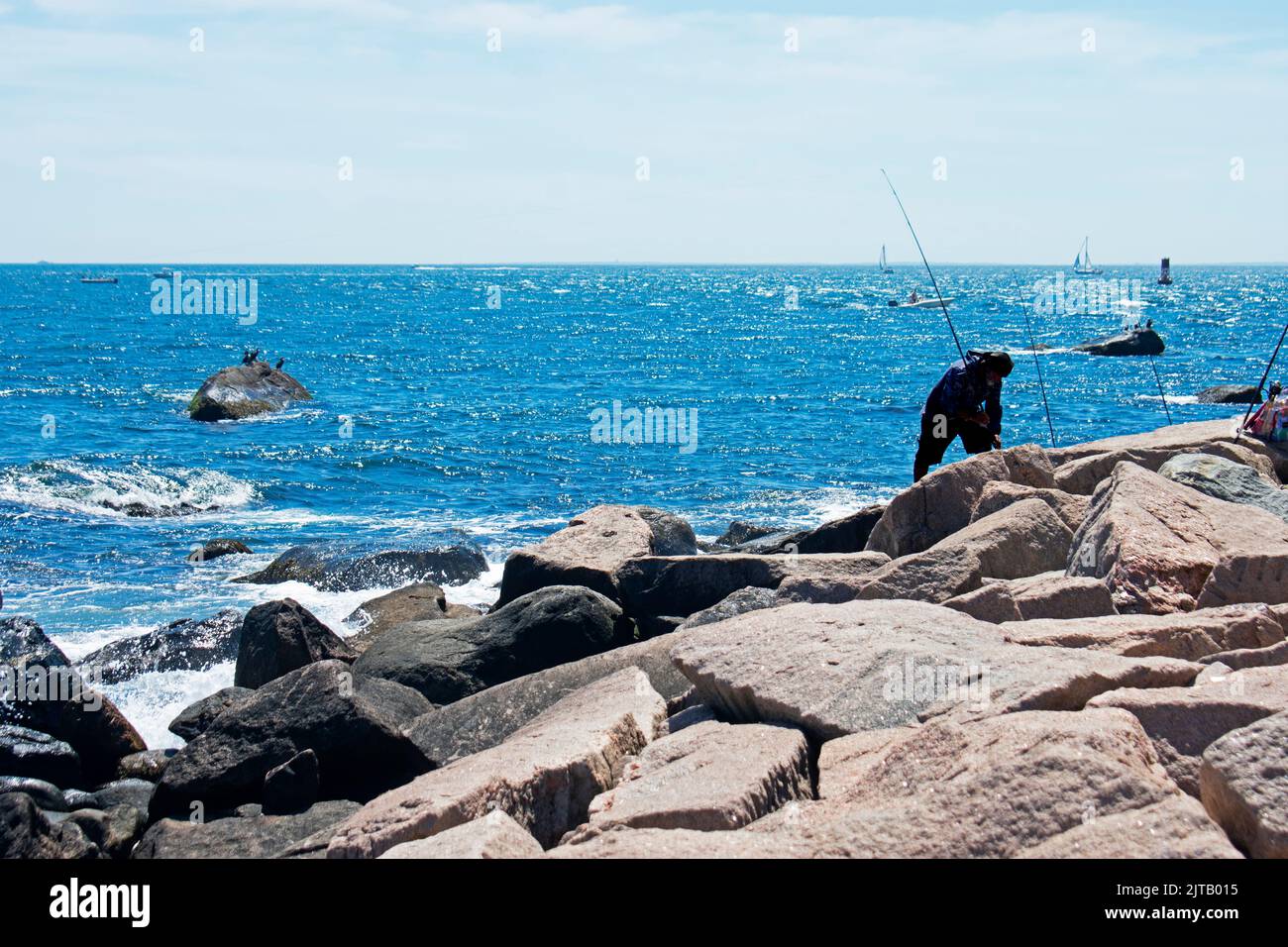 Fishermen fishing on rocky shore in Westerly, Rhode Island on a sunny day -06 Stock Photo
