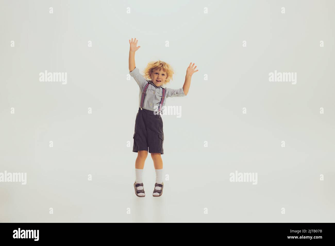 Portrait of little boy, child in suspenders and shorts playing, posing