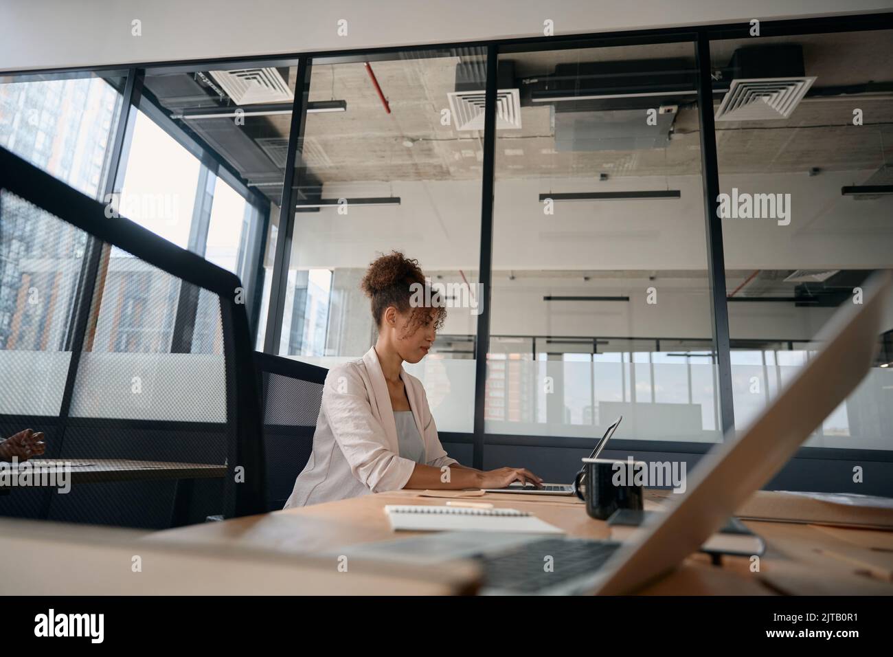 African american woman working on laptop in loft style coworking Stock ...