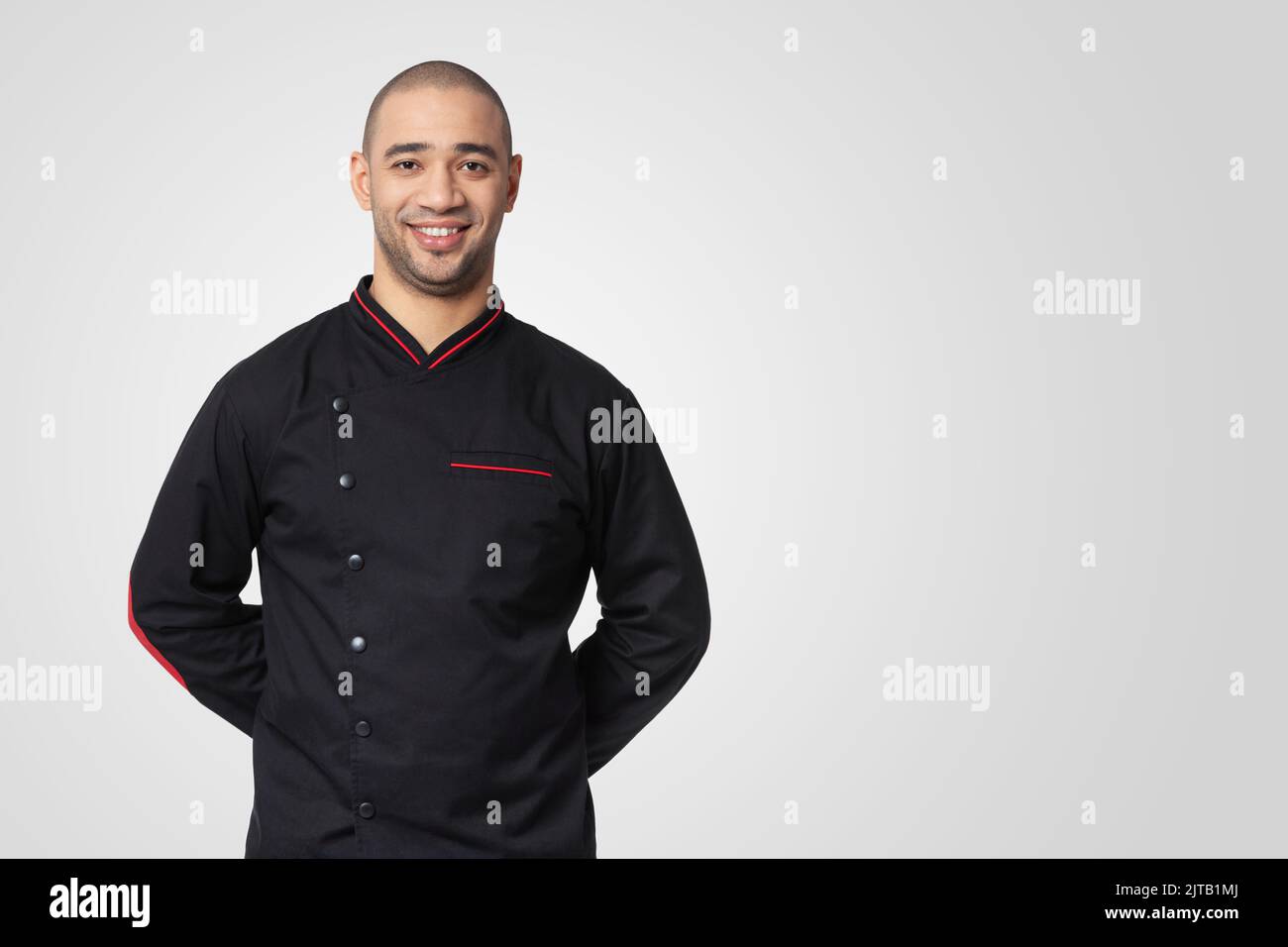 Portrait of happy professional cook isolated on white. Stock Photo
