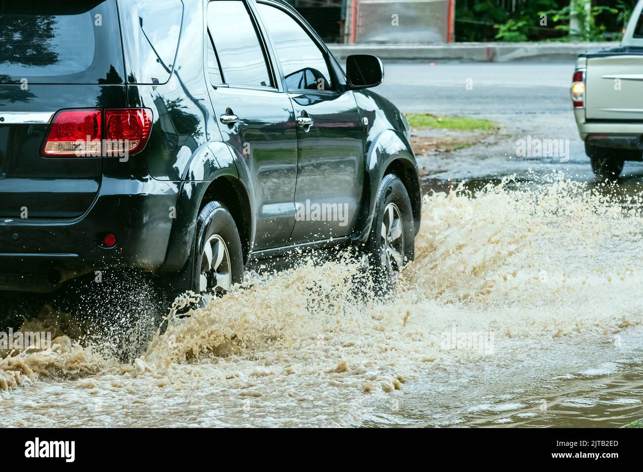Car passing through a flooded road. Driving car on flooded road during
