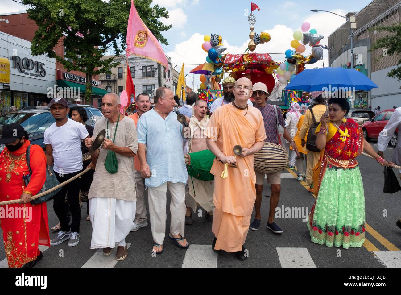 At the start of the Queens Ratha Yatra Parade, Hindu men & women play hand cymbals and drumsl. On Liberty Avenue in Richmond Hill, Queens, NYC Stock Photo