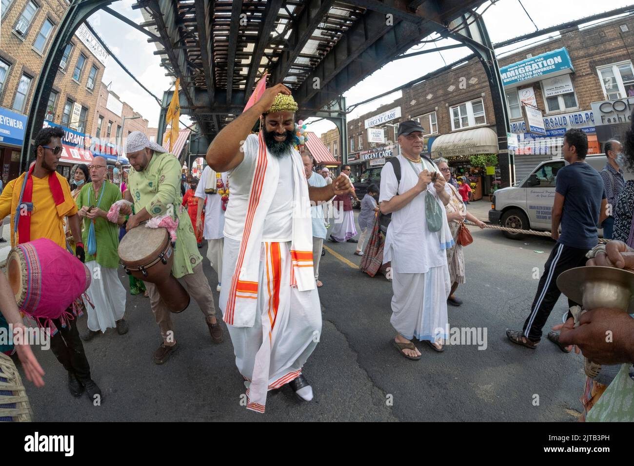 Devout Hindu men & women march, chant and dance under the elevated A train celebrating the 2022 Ratha Yatra in Richmond Hill, Queens, NYC Stock Photo