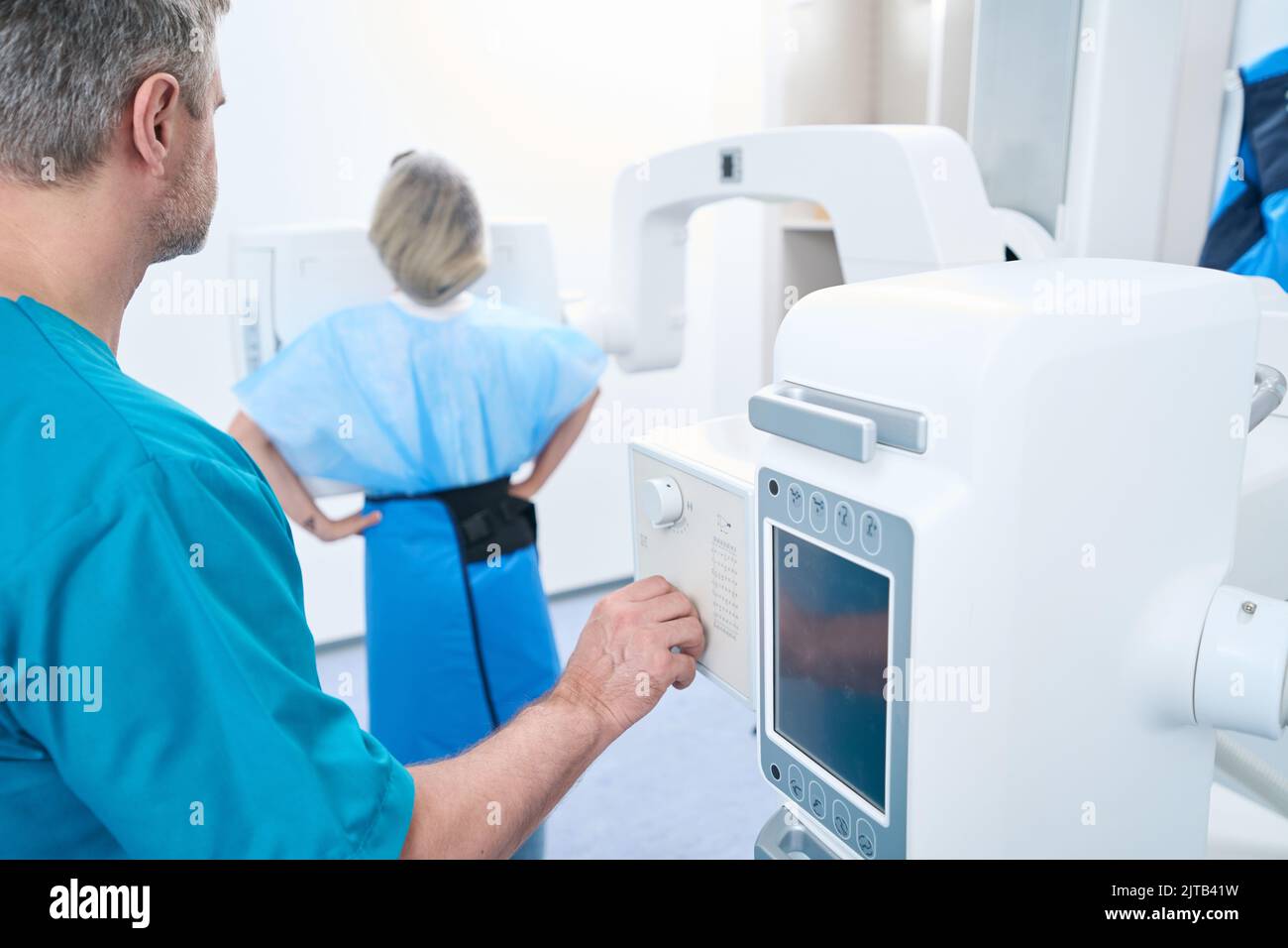 Radiologist preparing female patient for chest x-ray Stock Photo - Alamy