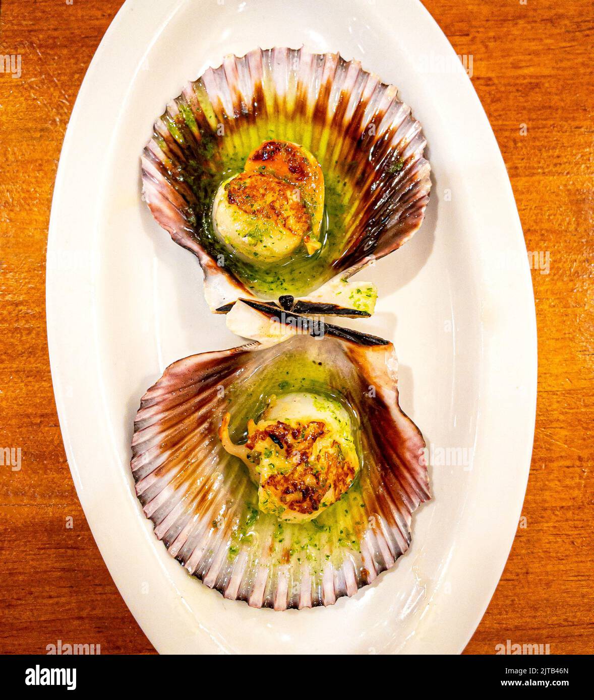 Pintxo of grilled scallops on the grill, seasoned with parsley oil. San Sebastian cuisine. Stock Photo