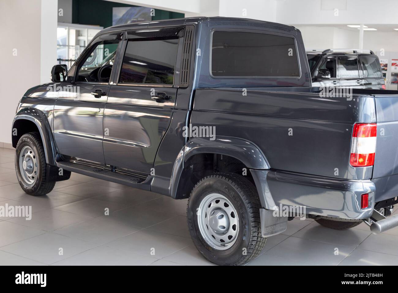 Russia, Izhevsk - August 20, 2021: UAZ showroom. New modern pick up UAZ Patriot in dealer showroom. Sollers automotive group. Back and side view. Stock Photo