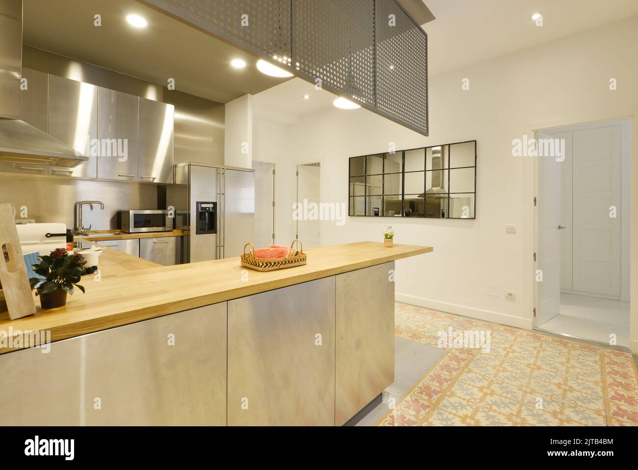 open kitchen, with a long rectangular dining island with wooden ...