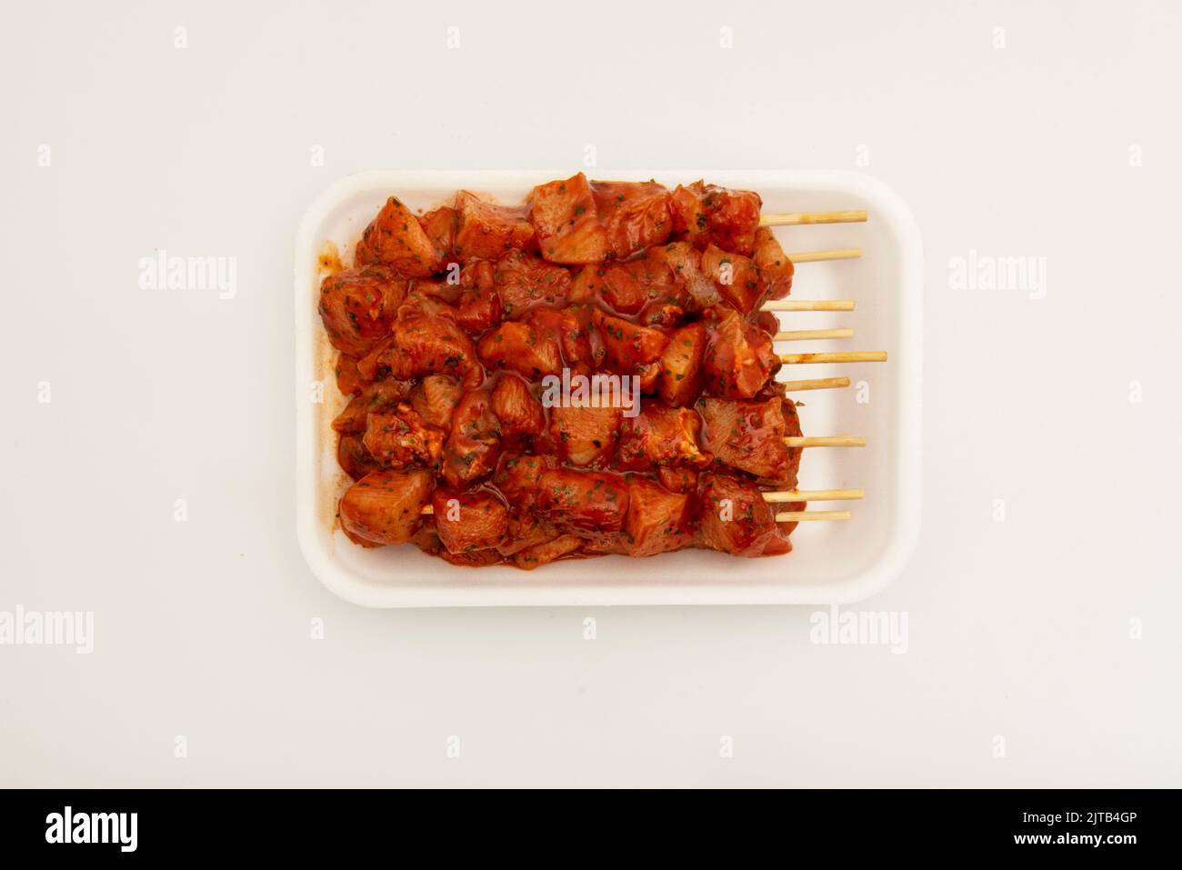 Moorish marinated chicken skewers with wooden sticks on a white polystyrene tray Stock Photo