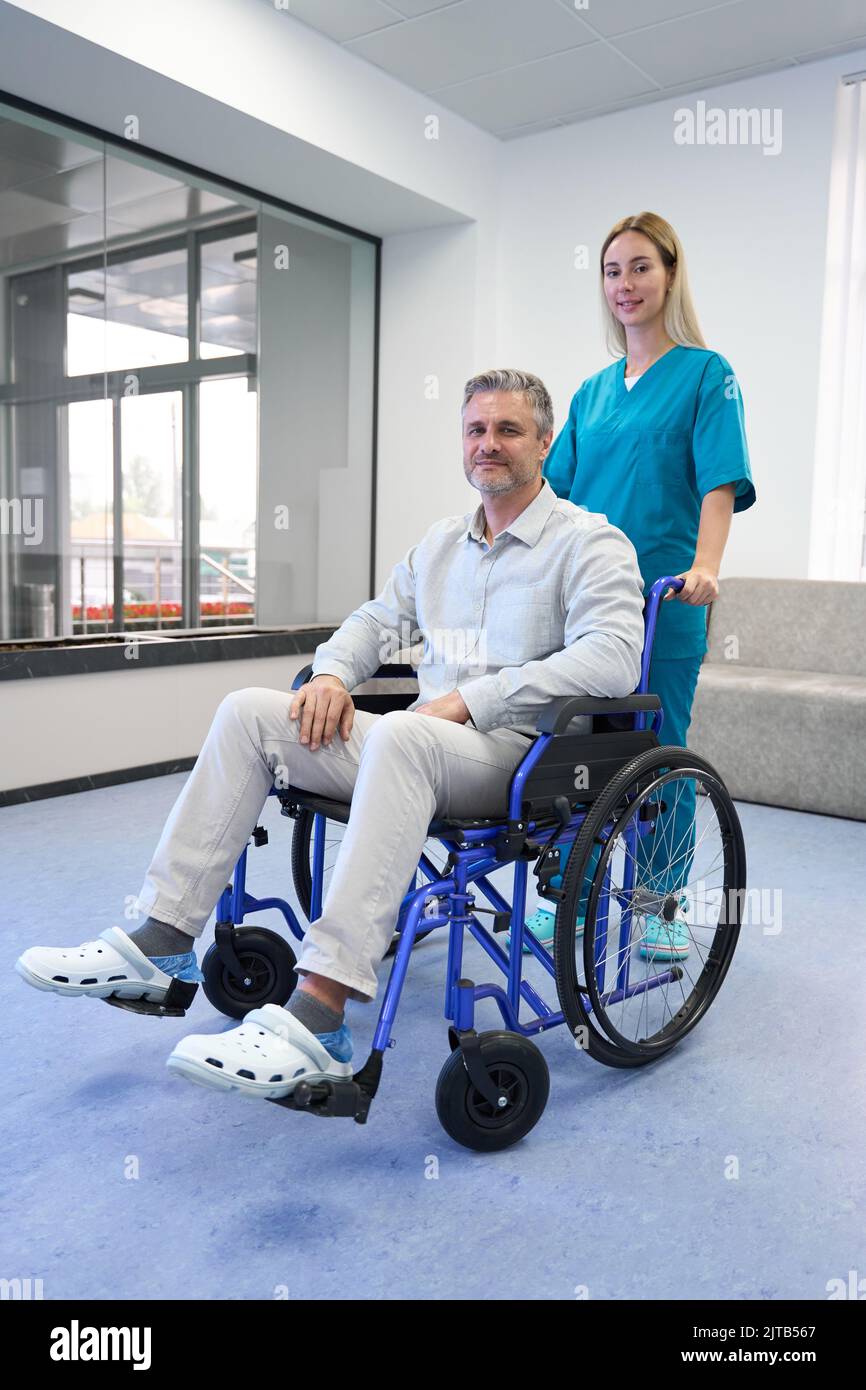 Doctor and patient in wheelchair looking at camera Stock Photo Alamy