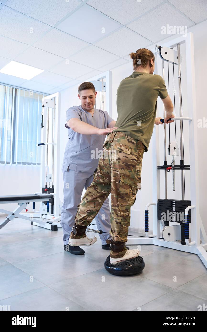 Physiotherapist helps patient recover from injury in military medical center Stock Photo