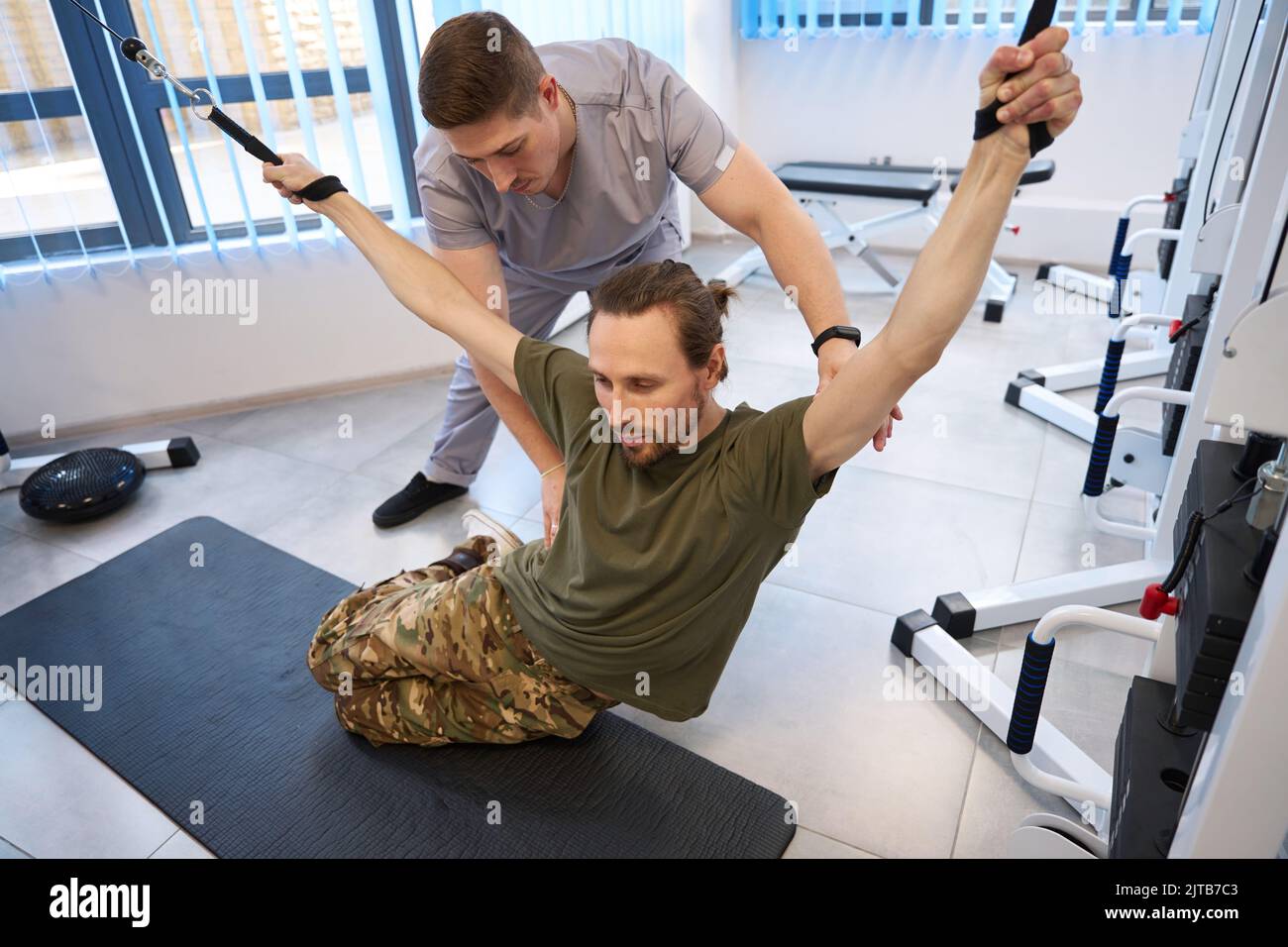 Physical therapist helping patient recover from spinal injury Stock Photo