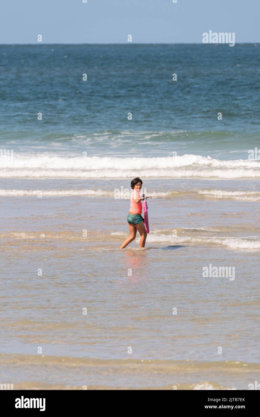 boy with orange equipment and bodyboard practices in the waves of Aveiro beach Stock Photo