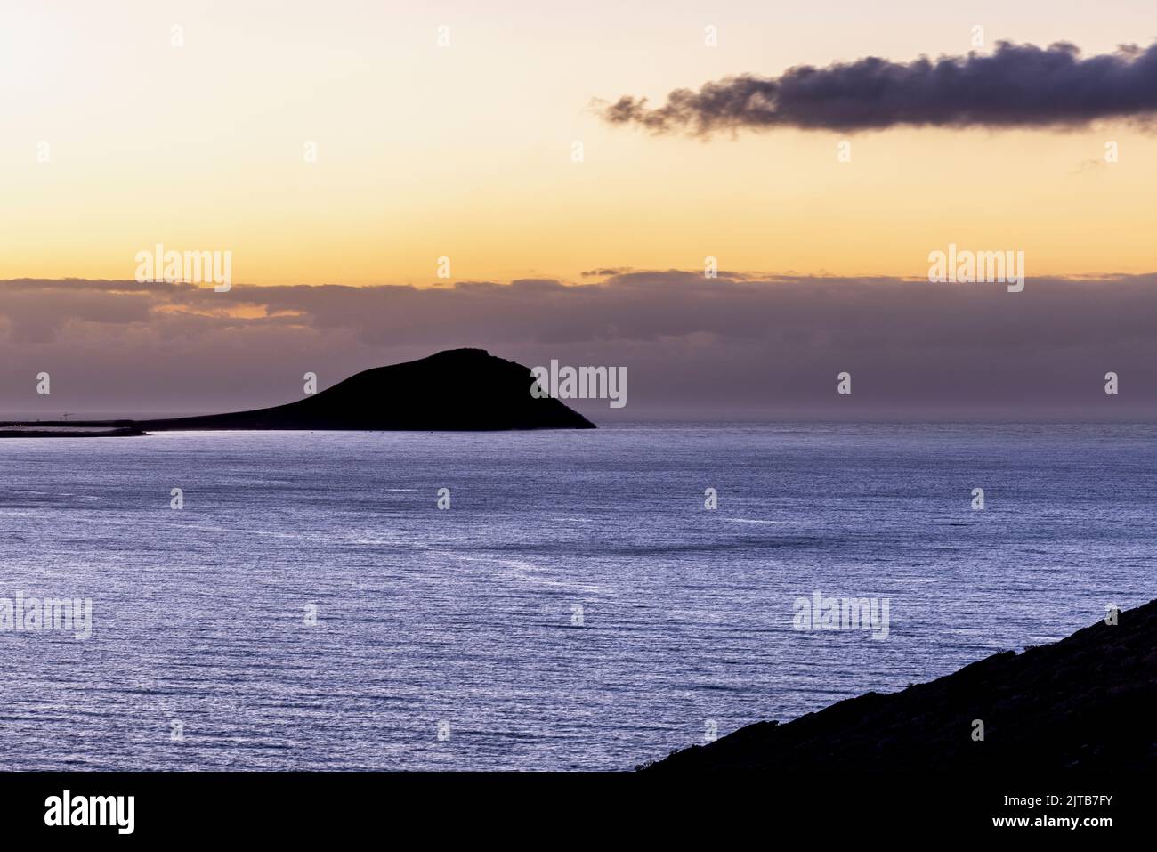 Red mountain, Montaña Roja in silhouette at sunrise. Dawn on the east coast of Tenerife, Canary Islands, Spain Stock Photo