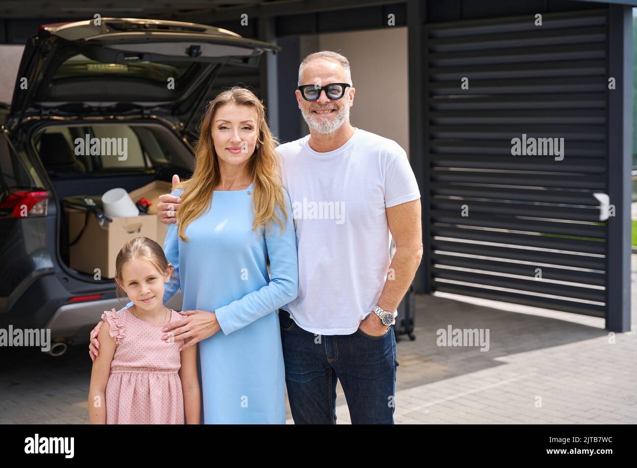 Happy family is photographed near new house. House moving concept Stock Photo