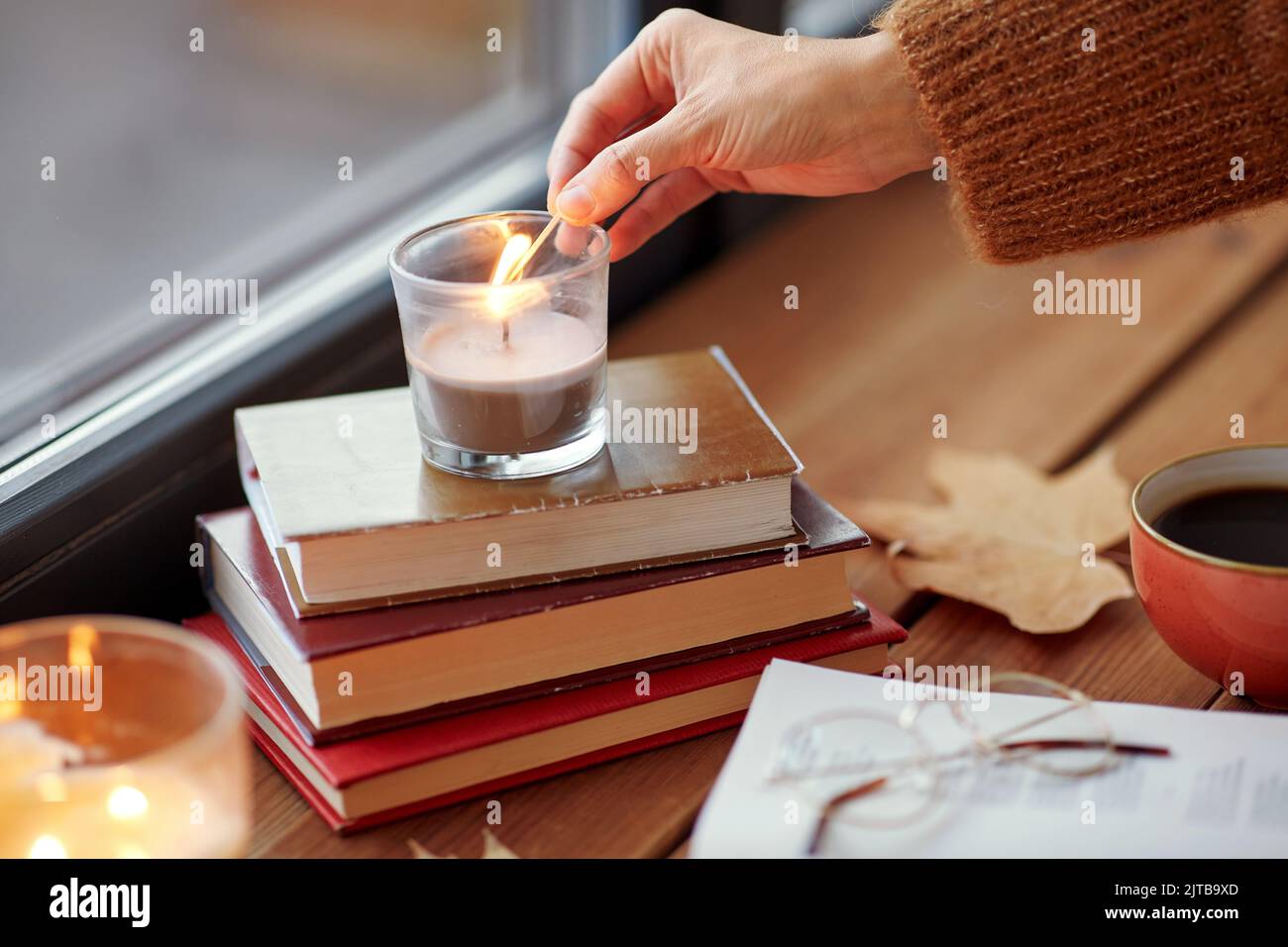 hand with match lighting candle on window sill Stock Photo Alamy