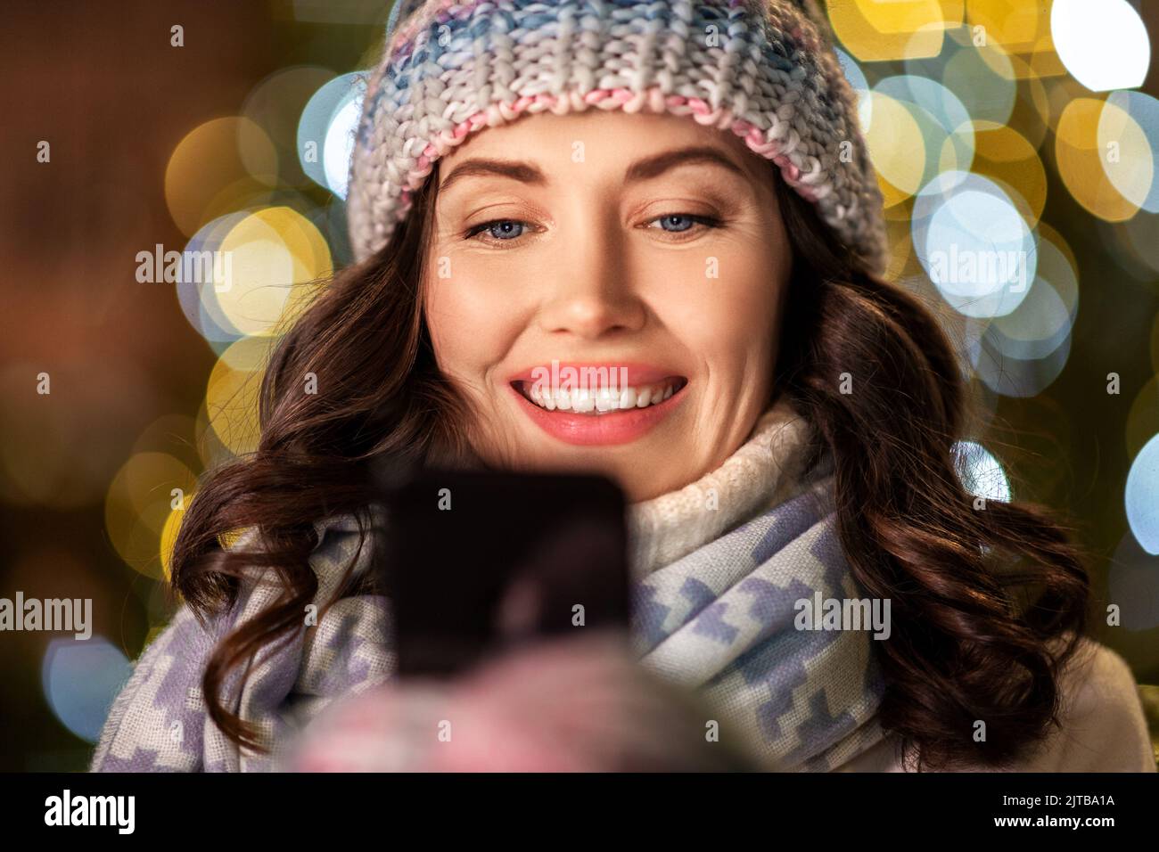 happy woman with smartphone in christmas city Stock Photo