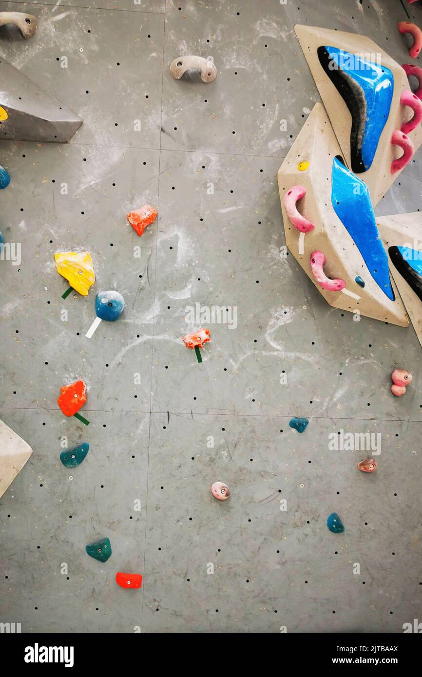 Artificial rock climbing bouldering wall showing various colored grips