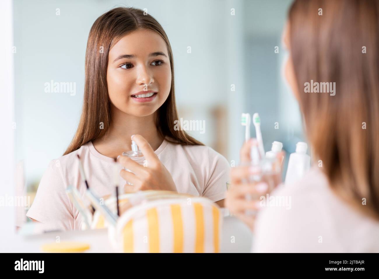 teenage girl spraying perfume at bathroom Stock Photo Alamy