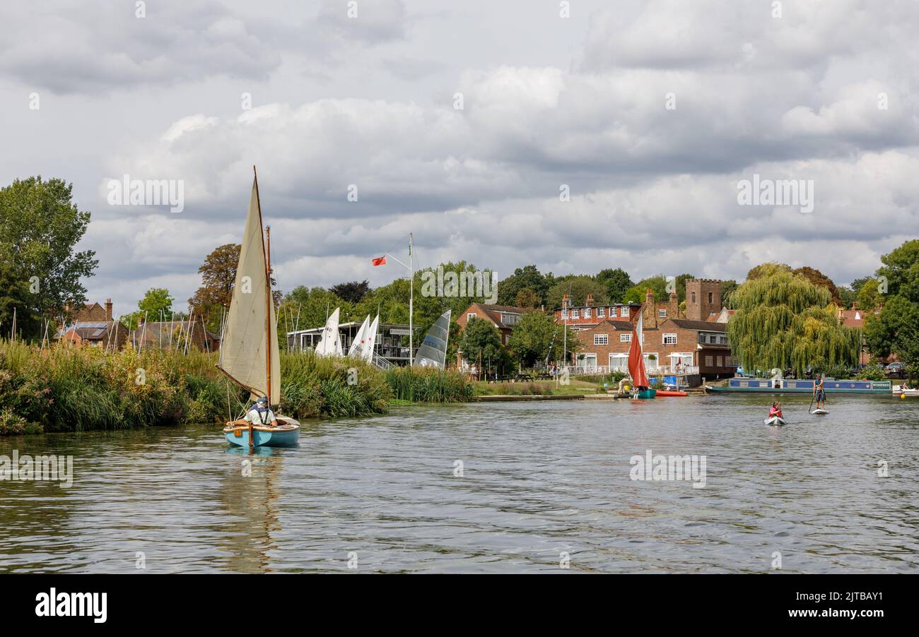 People in a sailing dinghy on the picturesque River Thames in summer