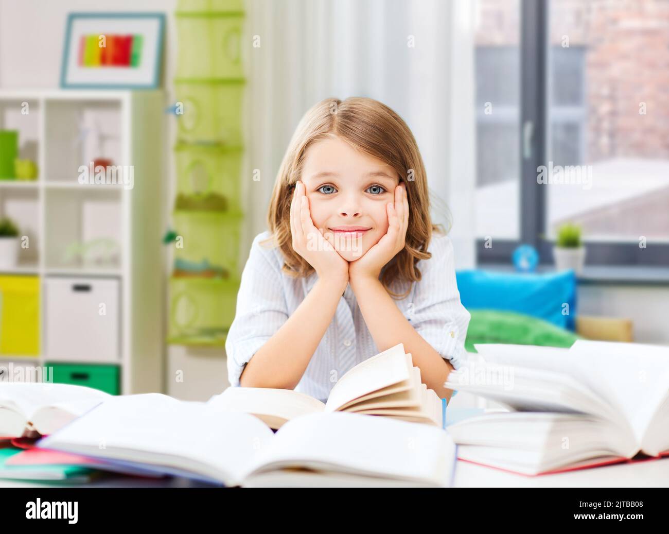 smiling student girl reading book at home Stock Photo - Alamy