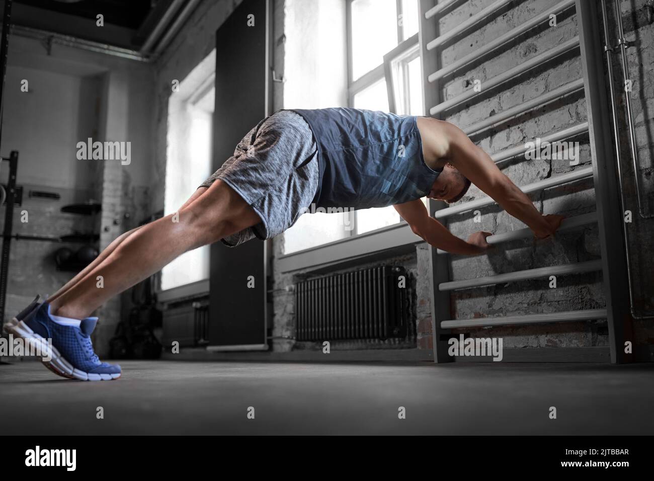 man exercising on gymnastics wall bars in gym Stock Photo