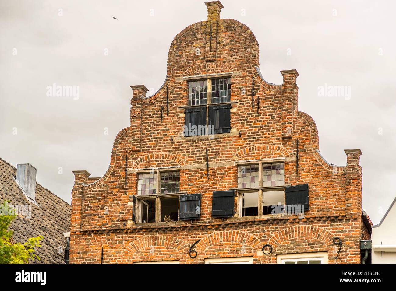 Deventer, Netherlands. A beautiful Dutch brick gable with decorative cat in the window Stock Photo